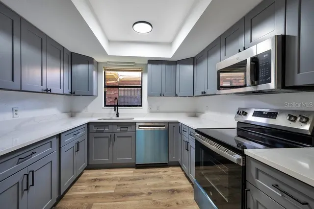 a kitchen with stainless steel appliances granite countertop a sink stove and microwave