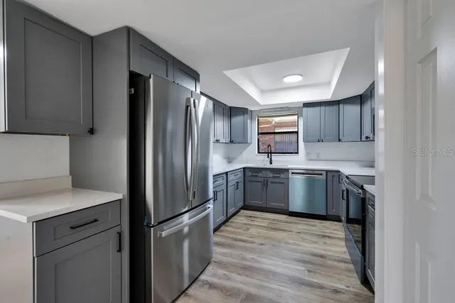a kitchen with stainless steel appliances granite countertop a refrigerator and a stove top oven