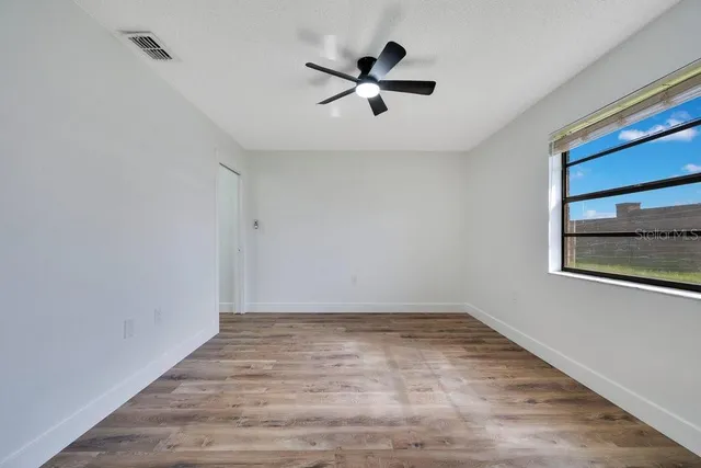 a view of empty room with wooden floor