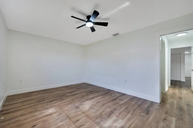 a view of empty room with wooden floor