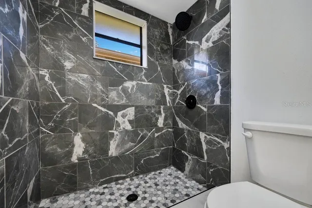 a bathroom with a toilet and a shower