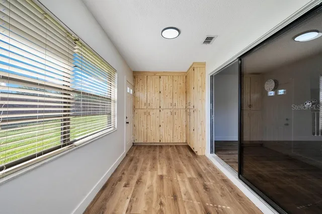 a view of a room with wooden floor and large windows