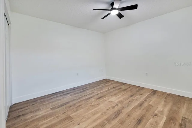 a view of a room with wooden floor and white walls