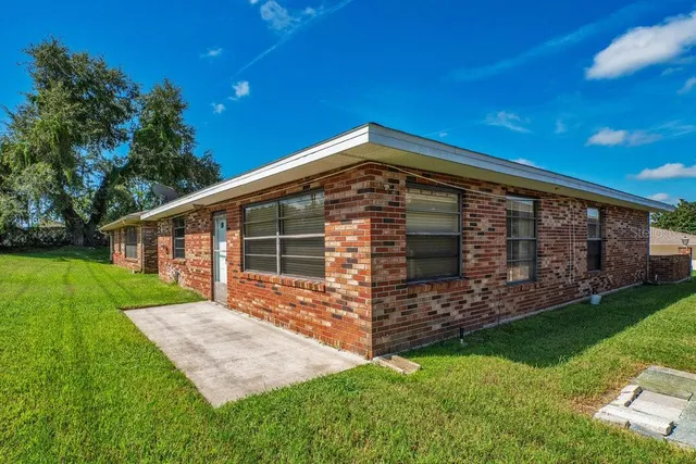 a view of a backyard with table and chairs and potted plants