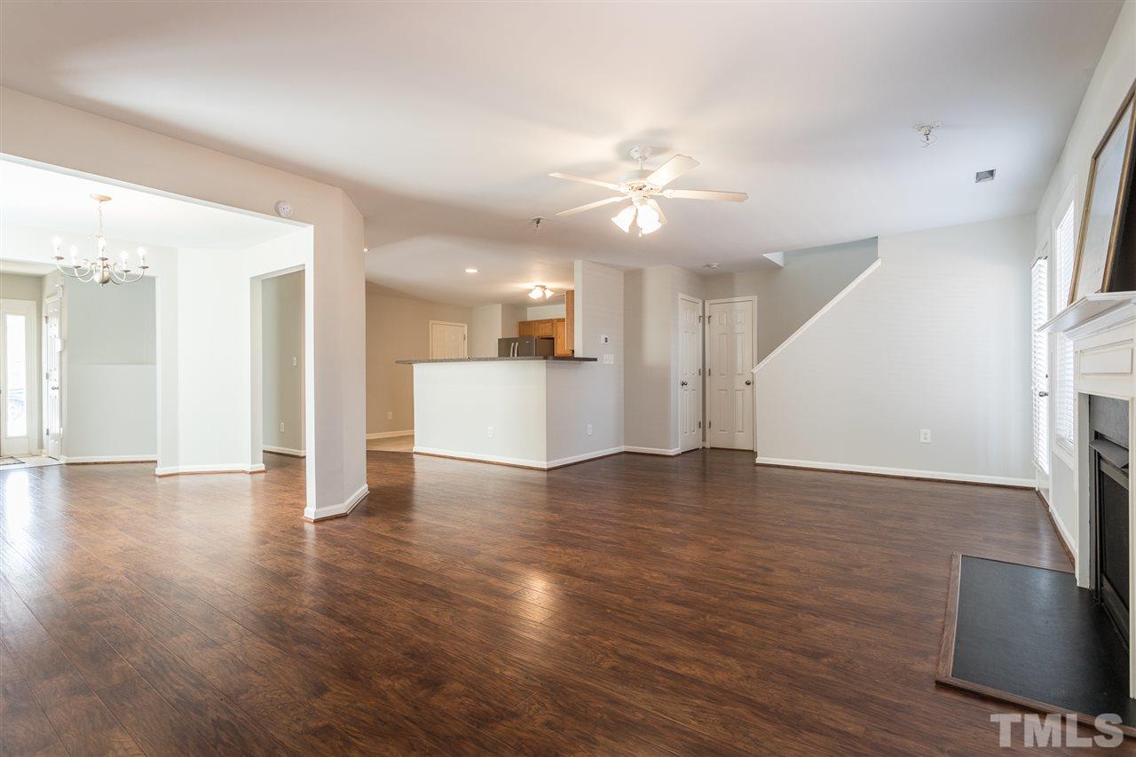 1017 Lombar Street Raleigh, NC 27610 - Photo 8 of 21 a view of an empty room with wooden floor and a kitchen