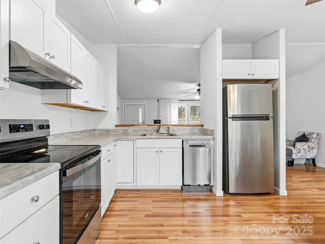a kitchen with a refrigerator stove and white cabinets