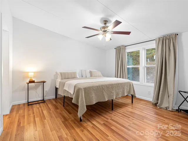 a spacious bedroom with a bed and wooden floor