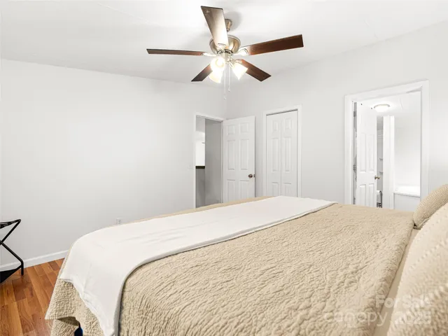 a spacious bedroom with a bed and a chandelier