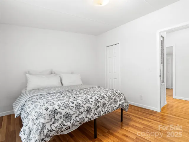 a bedroom with a bed and wooden floor