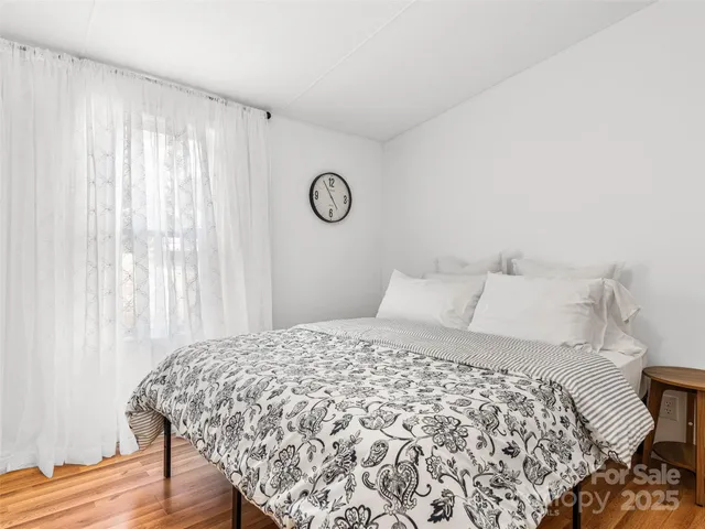a large bed sitting in a bedroom next to a window
