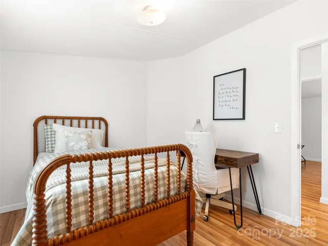 a view of a bedroom with furniture and wooden floor