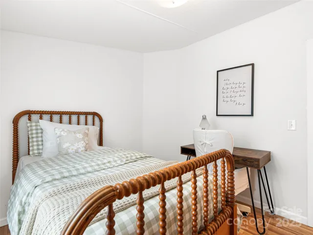 a bedroom with a bed and wooden floor