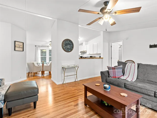 a living room with furniture and a wooden floor