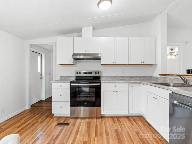 a kitchen with wooden floors and stainless steel appliances