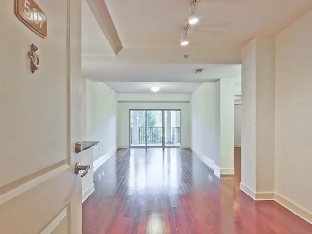 a view of an empty room with wooden floor
