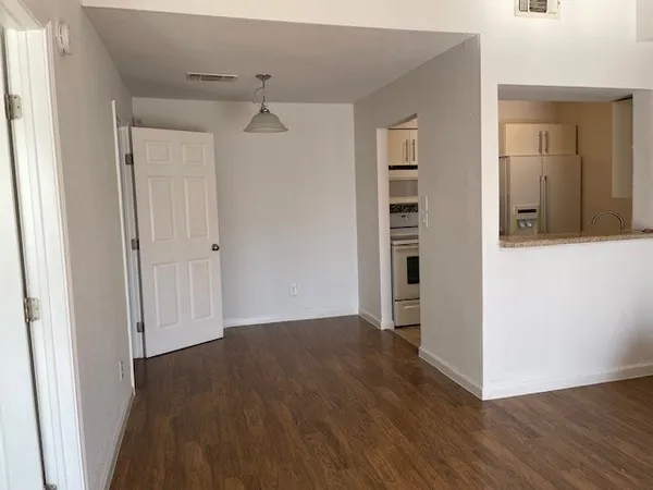 a view of a hallway with wooden floor and closet