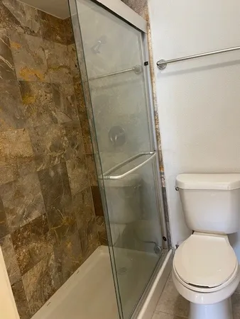 a bathroom with a toilet and a shower