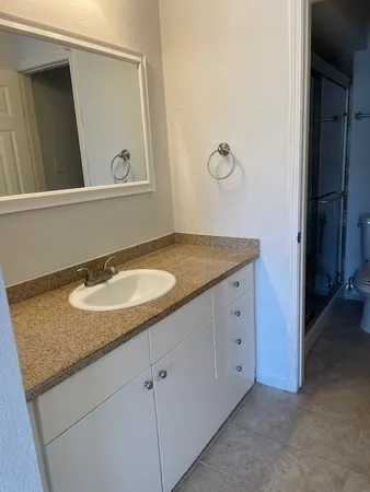 a bathroom with a granite countertop sink and a mirror