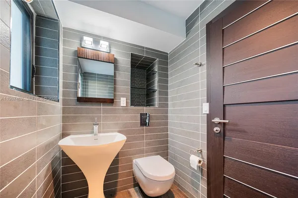 a bathroom with a toilet a sink and mirror