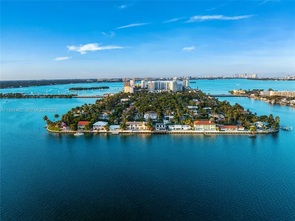 an aerial view of ocean and residential houses with outdoor space