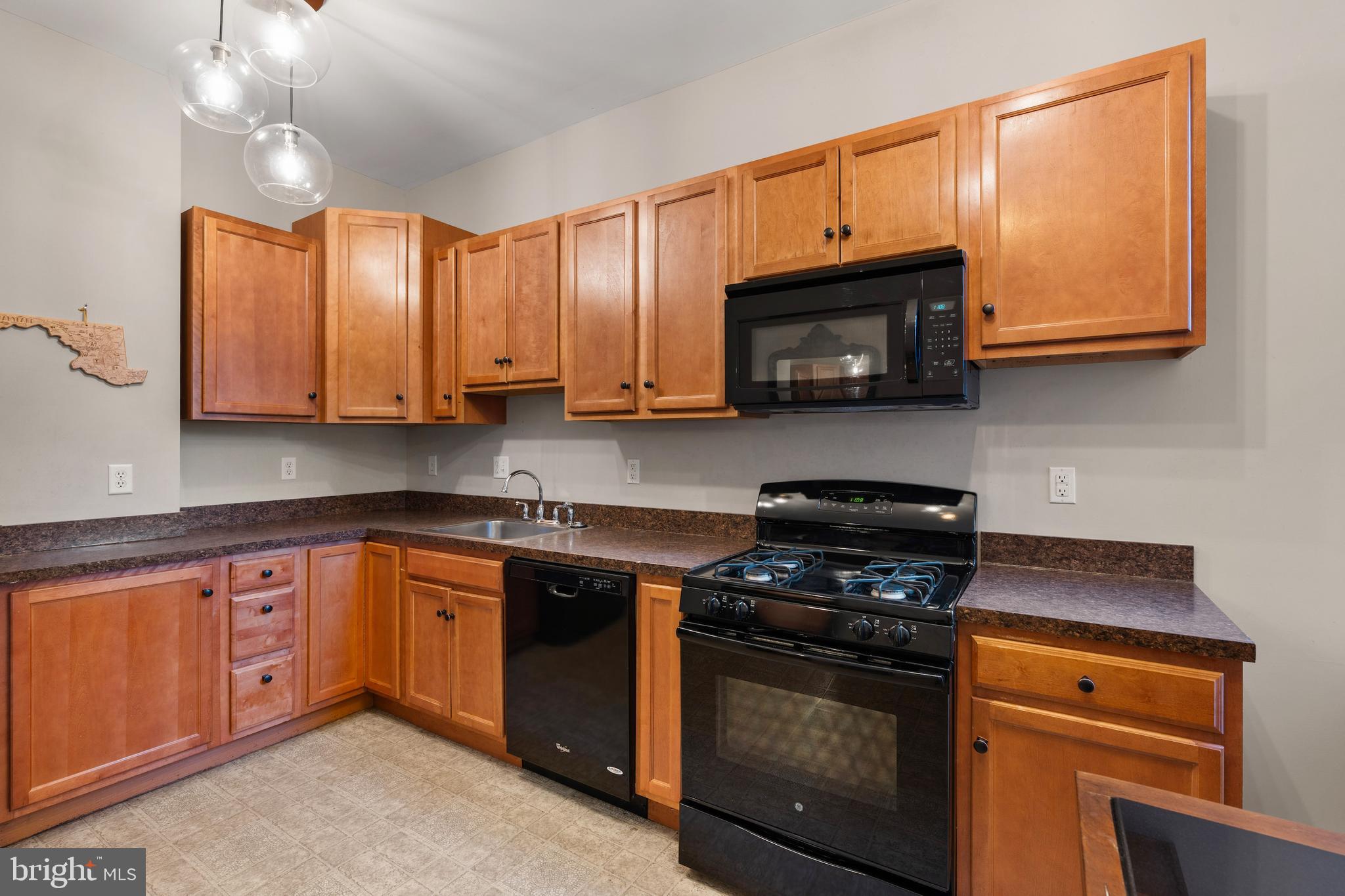 347 Yale Avenue Baltimore, MD 21229 - Photo 6 of 59 a kitchen with stainless steel appliances granite countertop wooden cabinets stove top oven and microwave