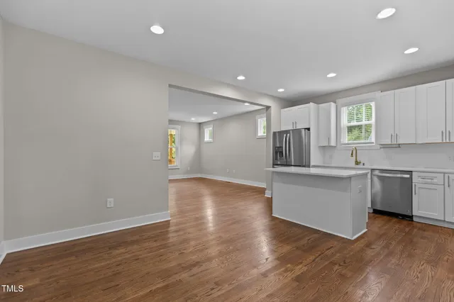 a view of an empty room and window and wooden floor