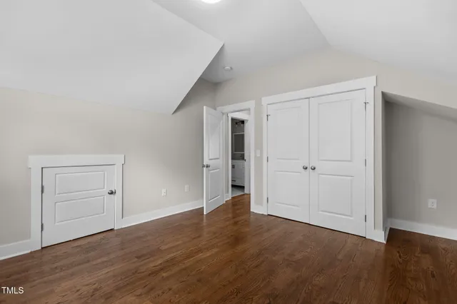 an empty room with wooden floor & closet area