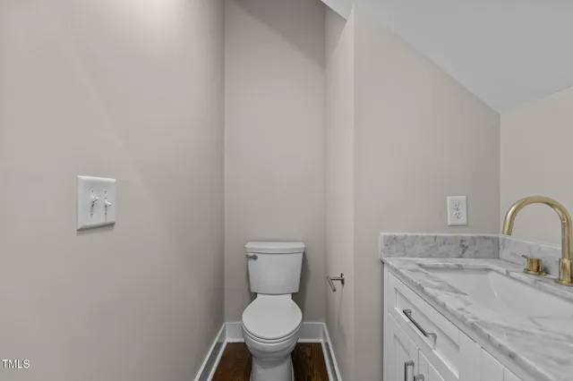 a bathroom with a granite countertop toilet and a sink