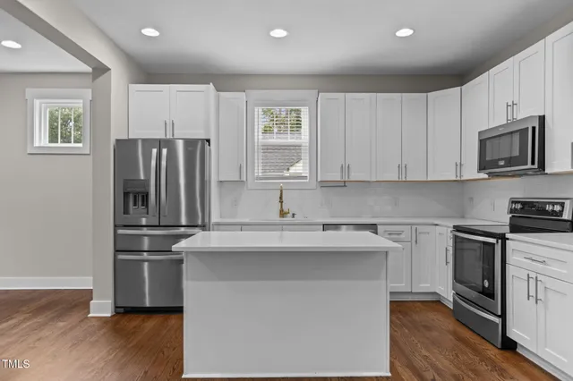 a kitchen with stainless steel appliances granite countertop a refrigerator a stove a sink and a microwave