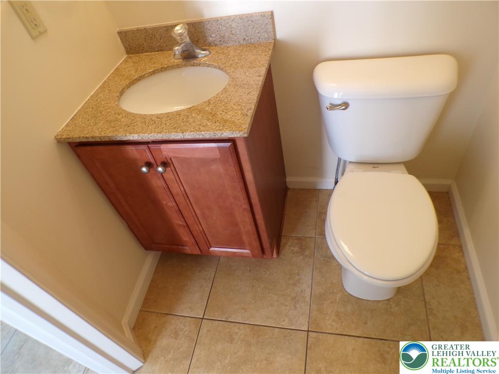 3283 Seip Road Macungie, PA 18062 - Photo 7 of 33 A compact 1st floor half bath featuring a granite-topped vanity and tile flooring.