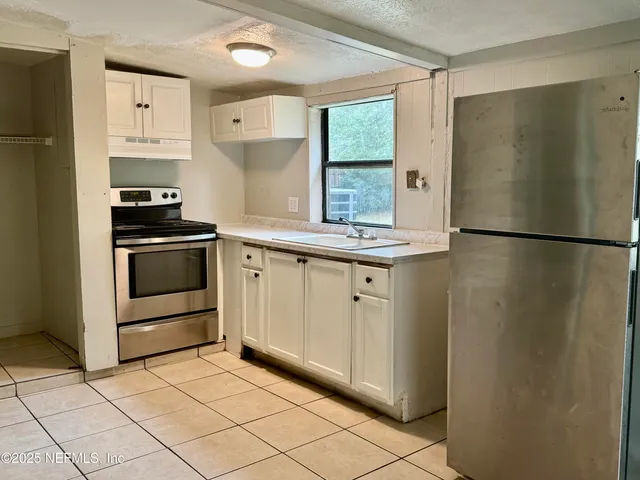 a kitchen with stainless steel appliances a refrigerator sink and cabinets