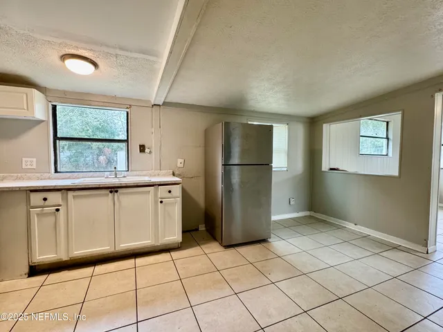 a kitchen with a refrigerator sink and cabinets