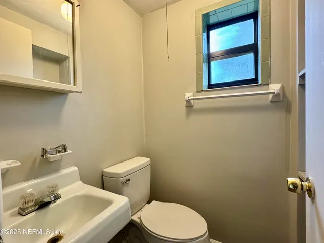 a white toilet sitting next to a bathroom sink