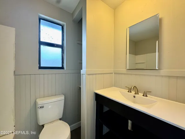 a bathroom with a toilet sink and mirror