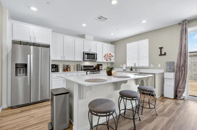 a kitchen with refrigerator a sink and chairs