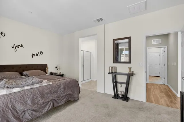 a bedroom with a bed a table and painting on the wall