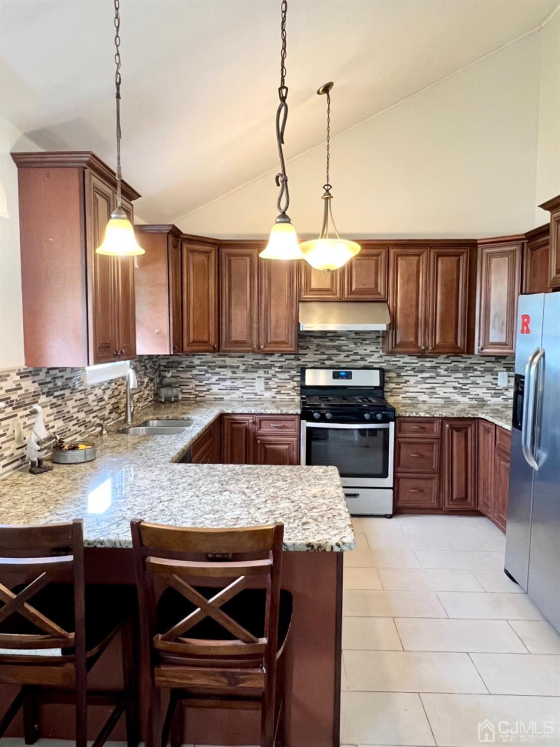 24 Sims Road Edison, NJ 08817 - Photo 6 of 16 a kitchen with a stove a sink a microwave and wooden cabinets