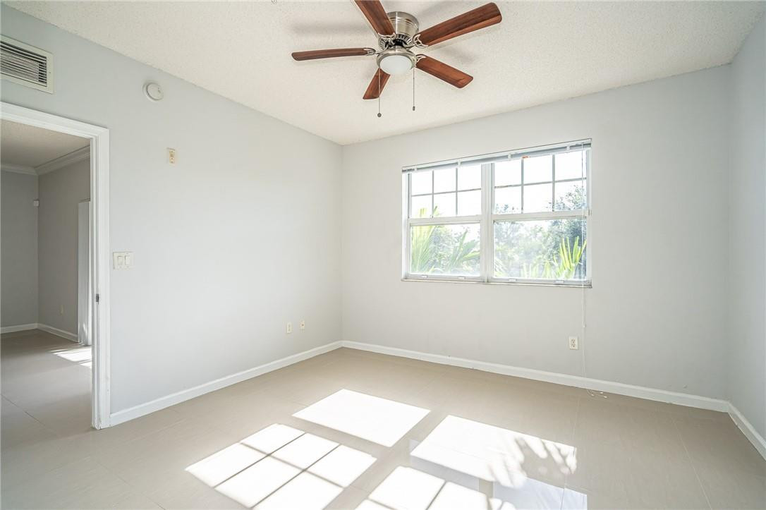 5860 West Sample Road, Unit 304 Coral Springs, FL 33067 - Photo 17 of 22 an empty room with a window and a fan