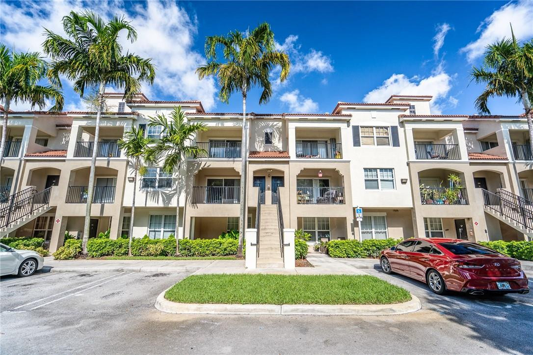 5860 West Sample Road, Unit 304 Coral Springs, FL 33067 - Photo 21 of 22 a front view of a residential apartment building with a yard