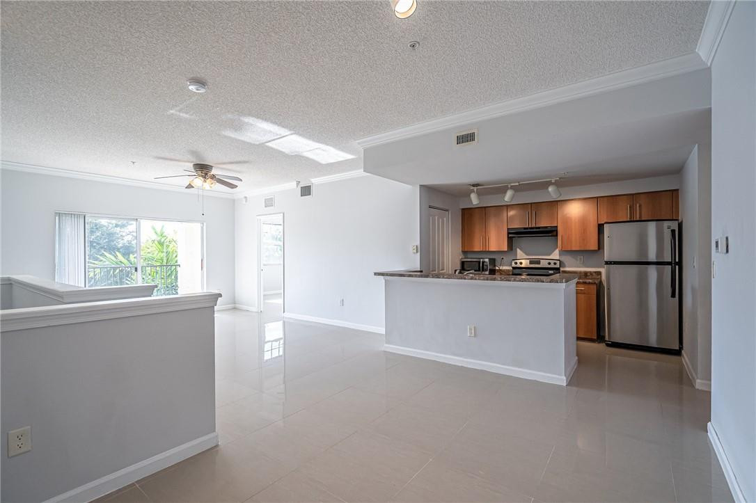 5860 West Sample Road, Unit 304 Coral Springs, FL 33067 - Photo 3 of 22 a kitchen with refrigerator and cabinets