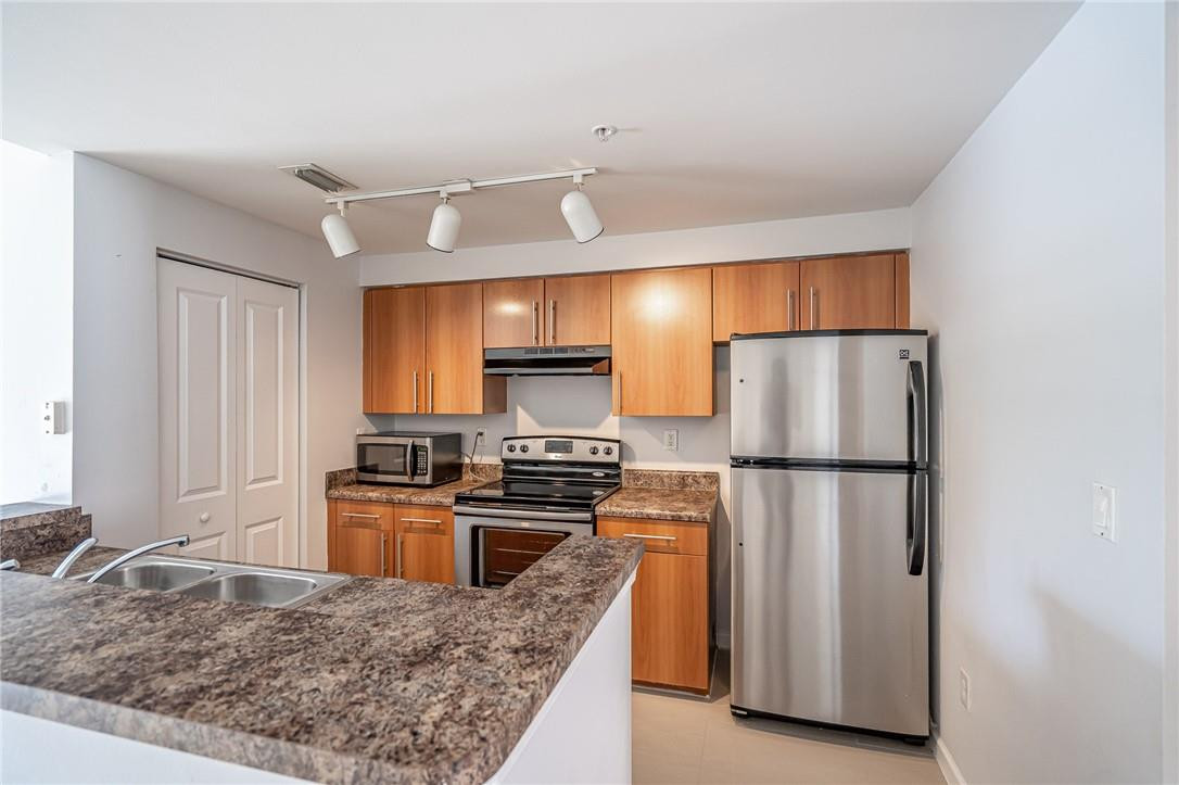 5860 West Sample Road, Unit 304 Coral Springs, FL 33067 - Photo 8 of 22 a kitchen with refrigerator a stove a sink and a refrigerator