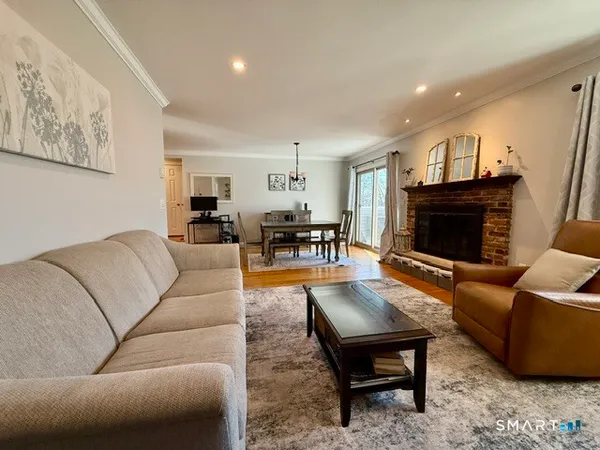 a living room with furniture a flat screen tv and a fireplace