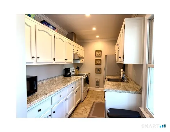 a kitchen with stainless steel appliances kitchen island granite countertop a sink and cabinets