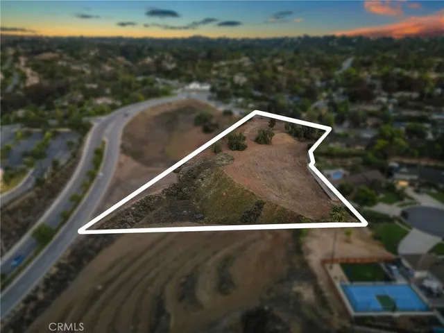 an aerial view of residential houses with outdoor space and trees
