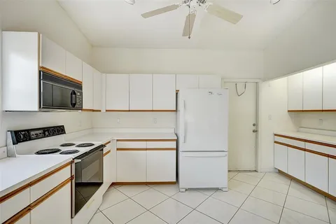 a kitchen with white cabinets and white appliances
