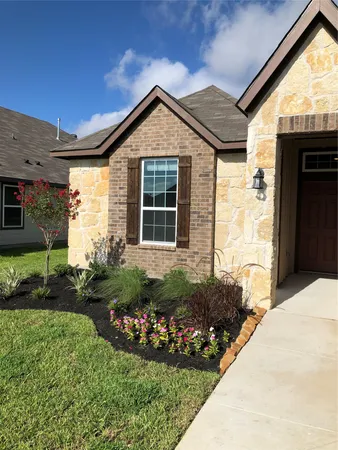 a front view of a house with a garden