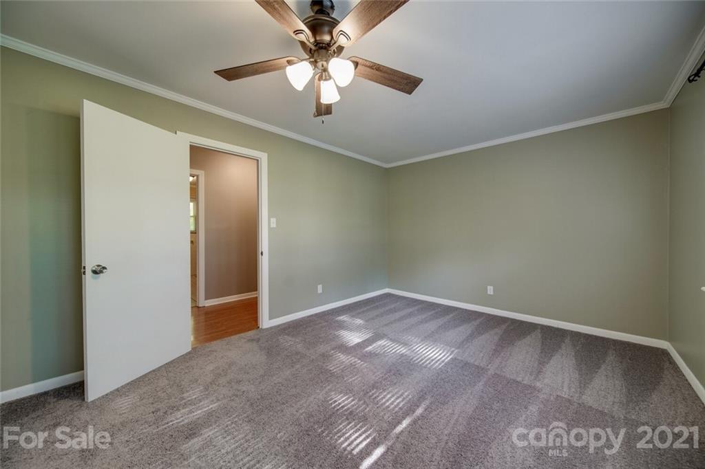 3802 Austin Road Monroe, NC 28112 - Photo 21 of 43 an empty room with a chandelier fan and windows