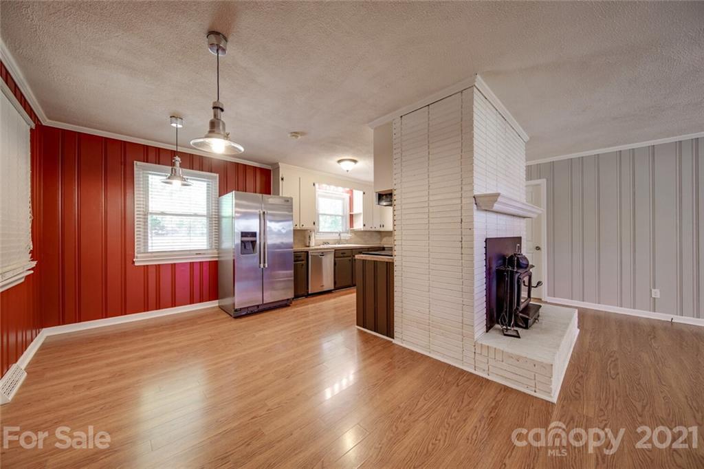 3802 Austin Road Monroe, NC 28112 - Photo 10 of 43 a kitchen with stainless steel appliances granite countertop a refrigerator a oven a sink dishwasher and a fireplace with wooden floor