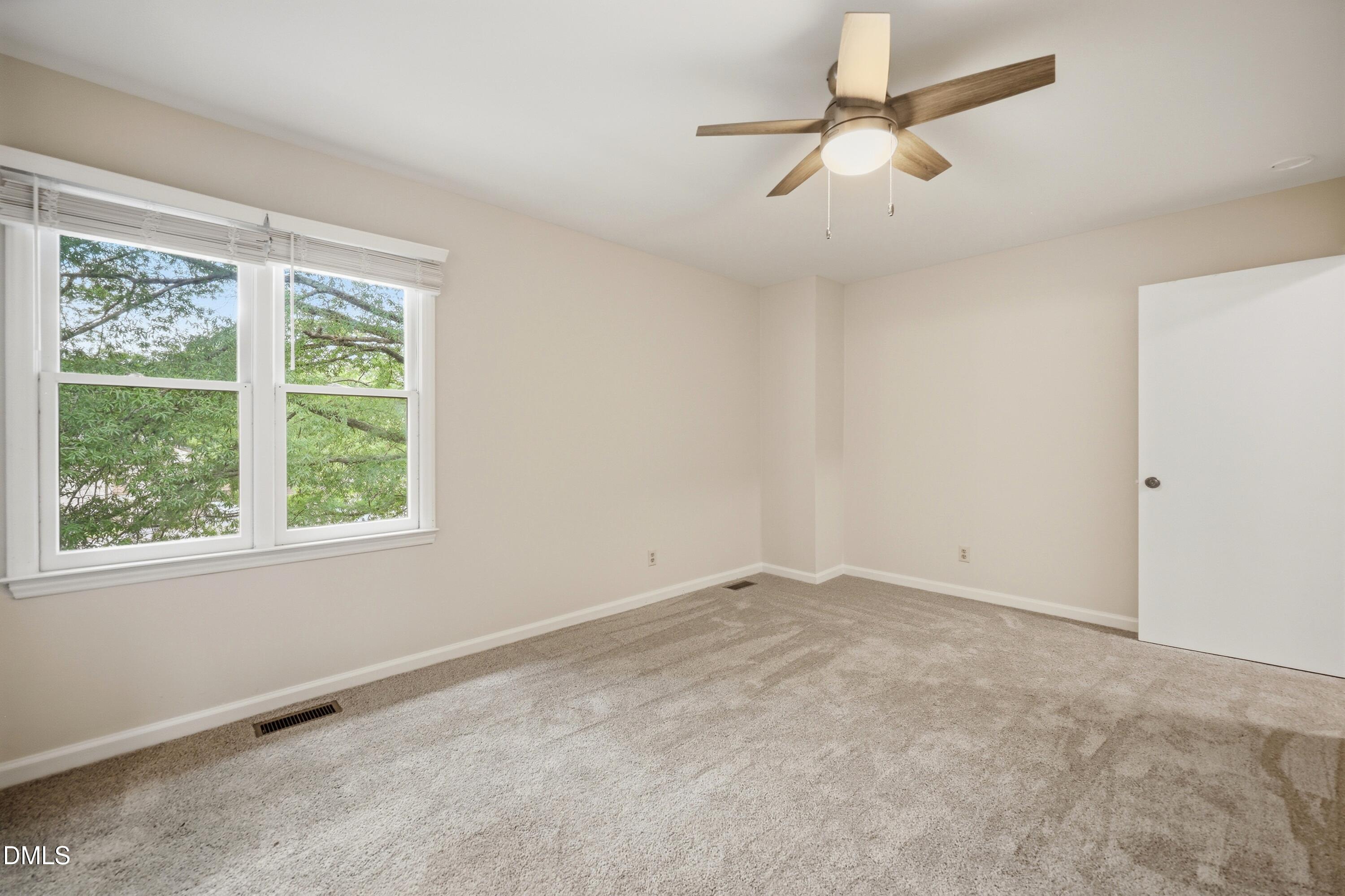 669 Bashford Road Raleigh, NC 27606 - Photo 7 of 19 an empty room with a window and a fan