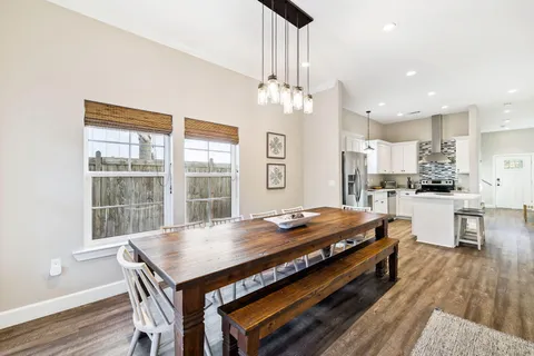 a living room with furniture kitchen view and a chandelier